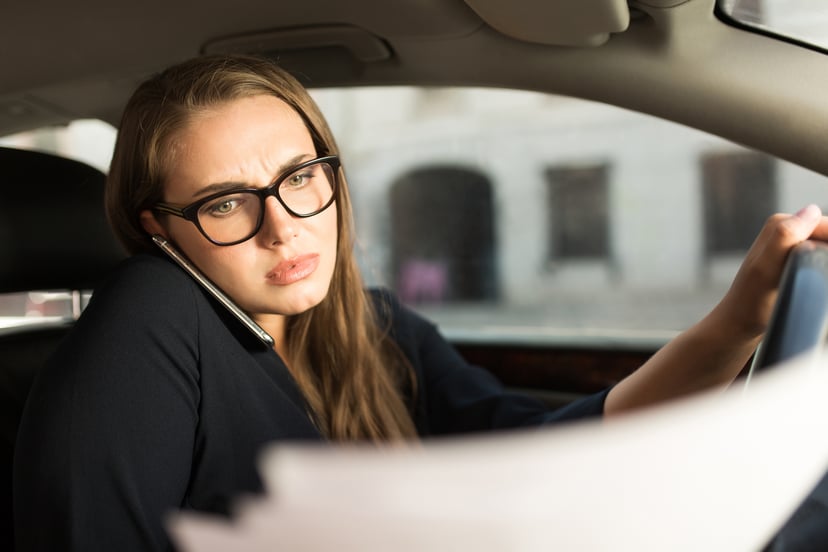 Young Serious Businesswoman Black Dress Eyeglasses Talking Cellphone Thoughtfully Looking Documents While Sitting Wheel Car